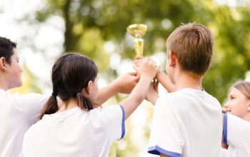 team-mates-holding-golden-trophy-together